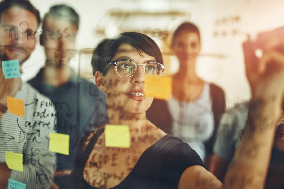 woman writing on wall whiteboarding process post its roadmap by peopleimages gettyimages 869651692